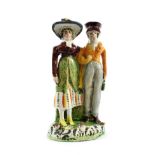 A Pearlware Figure Group of the Dandies, early 19th century, of traditional form, on a scroll