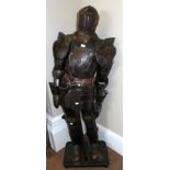 A Reproduction Suit of Armour, holding a sword, on an ebonised plinth, 177cm high overall