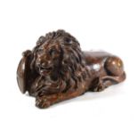 A Parcel Gilt Carved Wood Figure of the Lion of Lucerne, 19th century, recumbent, a forepaw on a