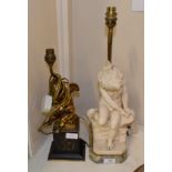 ^ A gilt metal cherub table lamp, on a black slate plinth; together with a figural table lamp of a