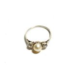 A cultured pearl and diamond three stone ring, a cultured pearl flanked by two old cut diamonds in