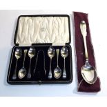 A collection of teaspoons and sugar tongs and a reproduction spoon
