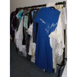 Rail of assorted circa 1960s and later mainly ladies clothing, including wedding dresses, evening