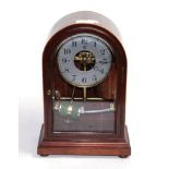 An electric mahogany veneered case mantel timepiece, silvered dial retailed by Harry Johnson,