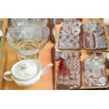 Four trays including crystal decanters with stoppers, knife rests, assorted drinking glasses and a