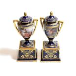 ^ A pair of Vienna porcelain twin handled vases and covers, raised on square bases, dark blue ground
