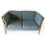 Stouby: A Danish Two-Seater Beech Framed Sofa, upholstered in blue cloth with six removable cushions