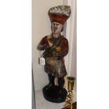 A carved and painted wood tobacconist advertising figure, modelled as a Highlander in traditional