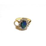 A black opal and diamond cluster ring, stamped '18CT', finger size Q. Gross weight 4.4 grams.