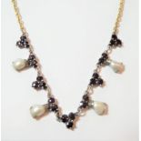A garnet and cultured pearl necklace, length 46cm . An applied plaque is present but indistinctly
