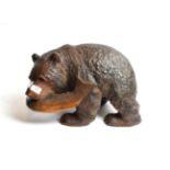 A wooden carving of a bear catching salmon