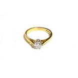 An 18 carat gold diamond solitaire ring, a round brilliant cut diamond in a white claw setting, to a