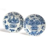 A pair of Chinese porcelain plates, Kangxi, painted in underglaze blue with a basket of flowers