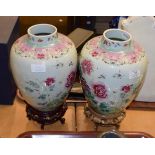 A pair of Chinese famille rose porcelain vases on pierced hardwood stands, circa 1920