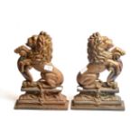 Pair of cast iron door stops in the form of lions bearing shields