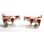 A pair of Staffordshire pottery cow creamers, mid 19th century, naturalistically modelled