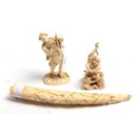 A carved ivory figure of a man with a staff, a carved Japanese figure with monkey, a carved