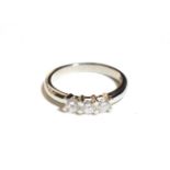 A platinum diamond three stone ring, three round brilliant cut diamonds in white claw settings to