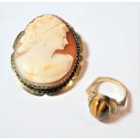 A 9 carat gold tigers eye cabochon ring, finger size L; and a cameo brooch, frame stamped '9CT',