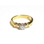 An 18 carat gold diamond solitaire ring, a round brilliant cut diamond in a claw setting, to channel