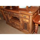 An early 20th century carved and burr wood breakfront sideboard