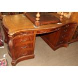 A George III style mahogany and crossbanded library desk, modern, the serpentine shaped top inset