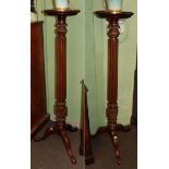 Two 19th century mahogany torcheres, the moulded dish tops over a reeded standard, raised on three