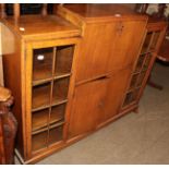 A 1950s oak bureau bookcase of squat form, the central fall front above a pair of cupboard doors