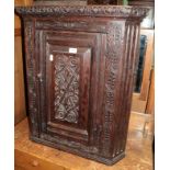 An 18th century carved oak hanging corner cupboard