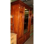 A Victorian mirror fronted panelled wardrobe fitted with two base drawers