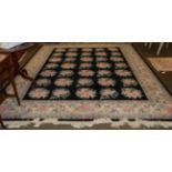 A Chinese floral carpet, the charcoal field of naturalistic flowers within ivory borders, 358 by