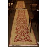 Pair of Agra design runners, each with a terracotta field of stylised flowers and plants enclosed by