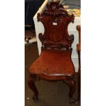 A Victorian mahogany hall chair, mid 19th century, the scrolled back support above a vacant