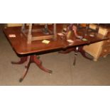 A George III style mahogany twin-pillar dining table, with one additional leaf, on turned supports