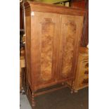 A Danish oak two door cabinet, walnut veneer panels, integral cornice, barley twist supports,