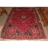 A Kashgai rug, the blood red field of stylised doves around a stepped medallion, framed by spandrels