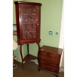 A reproduction mahogany and crossbanded five drawer chest and an Edwardian mahogany glazed corner
