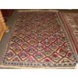 Wool carpet with natural ground, woven with a trellis of coloured flowers within a border of blue