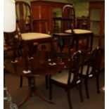 A reproduction twin pedestal dining table with six chairs (including two carvers)
