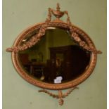 An oval bevelled wall mirror in the Adams style, 56cm by 60cm