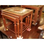 A pair of tile top nesting tables, the largest 53cm wide