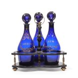 A Set of Three Blue Glass Mallet Decanters and Stoppers, circa 1790, gilt with scroll and lattice