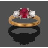 An 18 Carat Gold Ruby and Diamond Three Stone Ring, the oval mixed cut ruby flanked by two round