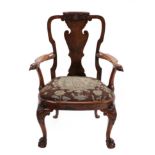 A Carved Walnut Armchair, possibly by Gillows, 19th century, the vasiform solid splat above outswept