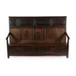 An Early 18th Century Joined Oak Settle, the back support with four carved panels with five