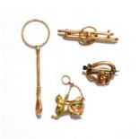 A 9 carat gold finger ring cigarette holder; two brooches, stamped '9CT'; and a charm stamped '