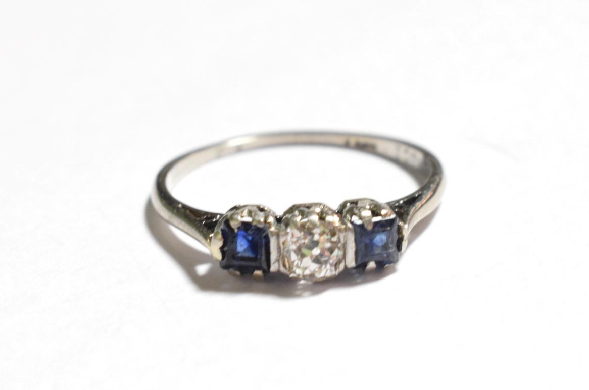 A sapphire and diamond three stone ring, stamped '18CT', estimated diamond weight 0.25 carat