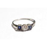 A sapphire and diamond three stone ring, stamped '18CT', estimated diamond weight 0.25 carat