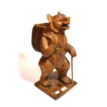 A modern carved Austro-German figure of a standing bear carrying a basket, 47cm high