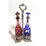 A silver plated three bottle decanter stand, the blue decanter with a silver collar